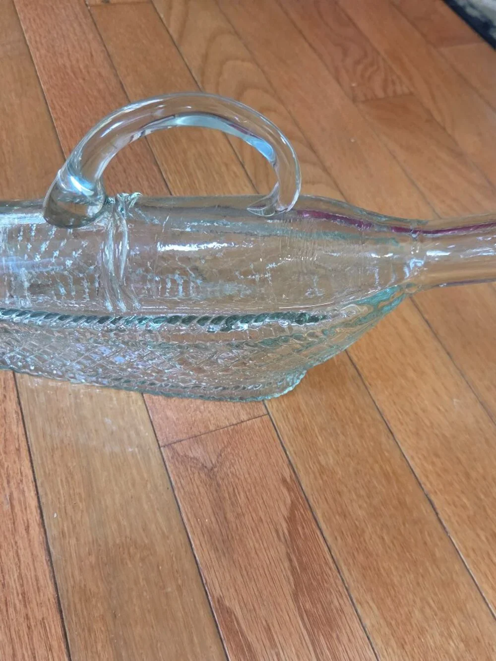 vintage molded clear wine decanter mimics a bottle resting in a basket